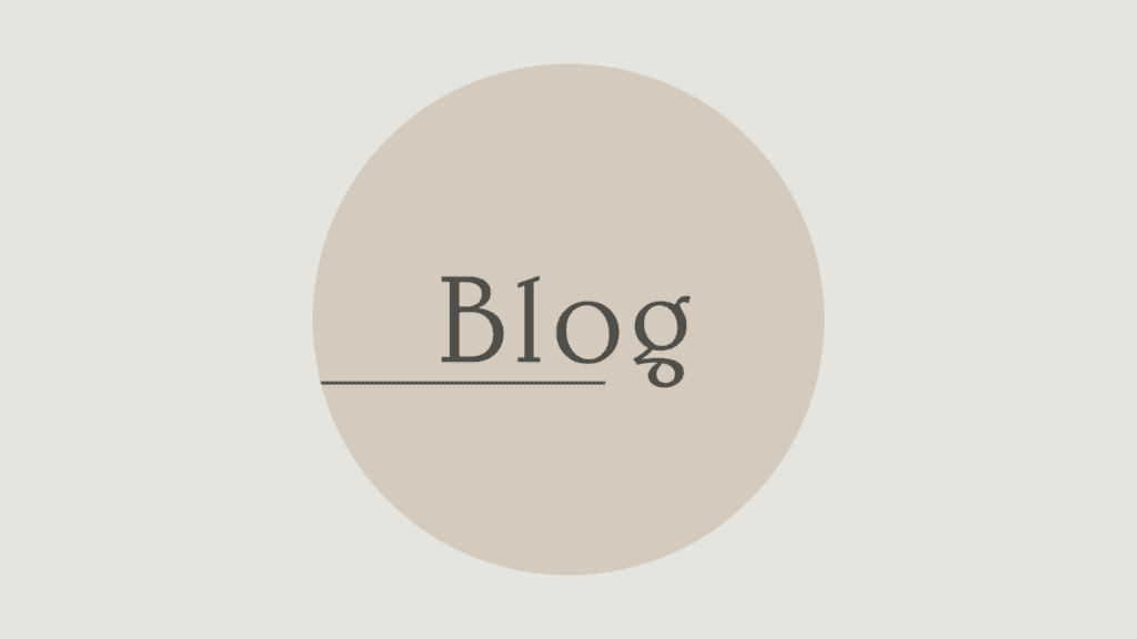 Schriftzug Blog in einem kreisrunden Element auf goldbraunem Hintergrund, der auf Blogartikel hinweisen soll